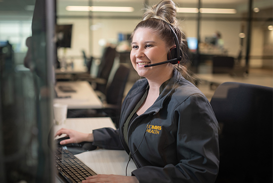 Customer service representative with headset working on computer.